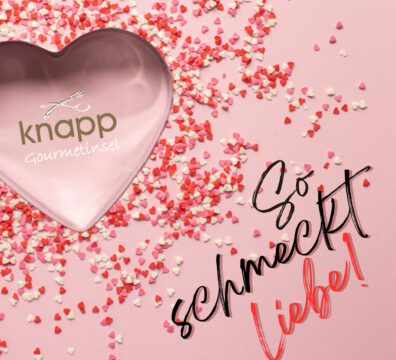 Herz Ausstechform mit knapp Logo auf rosa Hintergrund mit Herz Konfetti in Rot und rosa, Schriftzug "So schmeckt Liebe"